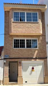 a large brick building with two white garage doors at Casa Frijol 20metres from the beach in Los Alcázares