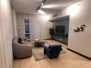 Una sala de estar con un sofá y un televisor. en 217 KING ABDULLAH ECONOMIC CiTY Family and business, en King Abdullah Economic City