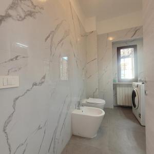 un bagno bianco con un water e un lavandino di La Casetta del 26 B&B a Corsico