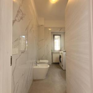 a white bathroom with a sink and a toilet at La Casetta del 26 B&B in Corsico