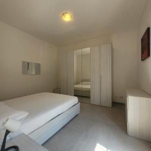 una camera da letto bianca con un letto e uno specchio di La Casetta del 26 B&B a Corsico