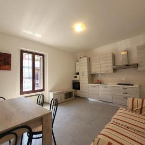 a kitchen with white cabinets and a table and chairs at La Casetta del 26 B&B in Corsico