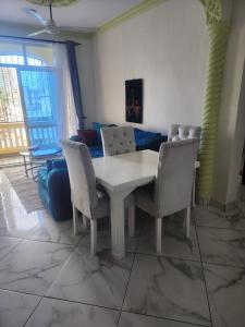 a living room with a table and chairs and a couch at The Blue Apartment Sparki in Mombasa