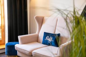 białe krzesło z niebieską poduszką w obiekcie Sielanka Pokoje Hotelowe, Restauracja - Ustroń w Ustroniu