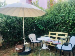 a table and chairs under an umbrella next to a bench at Art & Books Guesthouse Alexandroupoli in Alexandroupoli +21 photos