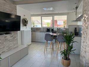 a kitchen with a table and chairs and a tv at Le Coeur Champêtre in Oberhoffen-sur-Moder