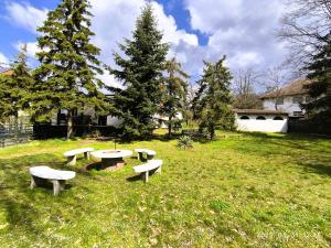 a group of picnic tables in a grass field at The Other House, Piliscsaba in Piliscsaba