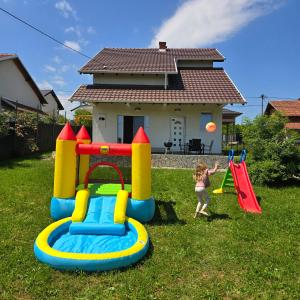 a little girl playing with a playground equipment in a yard at Sienas Holiday Home in Vrnjačka Banja