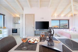 a living room with a table and two glasses of wine at Slavena Suite in Perivólia