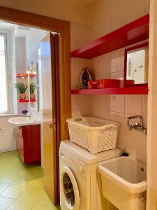 une salle de bain avec une machine à laver et un lavabo dans l'établissement Bnbook-Borromeo 2, à Rho