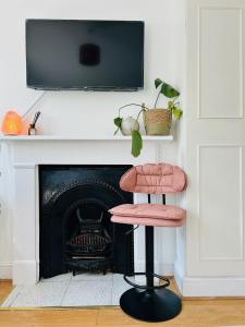 a pink chair sitting in front of a fireplace at Apollo Hammersmith Studio in London