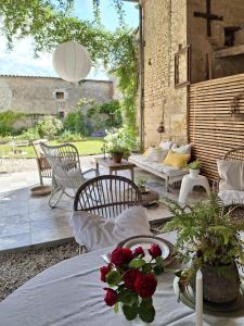 a patio with a table with flowers on it at La Maison Ânanda in Aigre