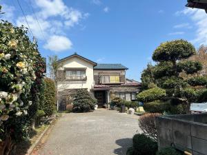 a house with a driveway in front of it at Chiba Homestay by Lek บ้านพักใกล้นาริตะโตเกียว in Yotsukaidō