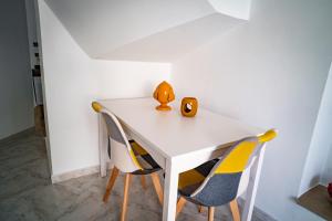 a white table with two chairs and a vase on it at Caravigna Love in Carovigno