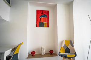a room with two chairs and a painting on the wall at Caravigna Love in Carovigno