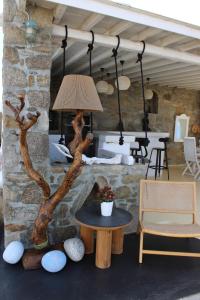 a room with a table and a stone wall at Vougli View Mykonos in Drafaki
