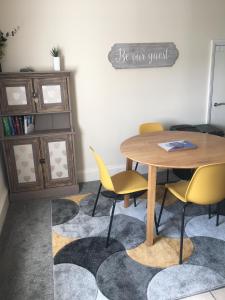 a dining room with a table and chairs on a rug at Peel House Apartments - Great for Professionals & Weekends Away in Burton upon Trent