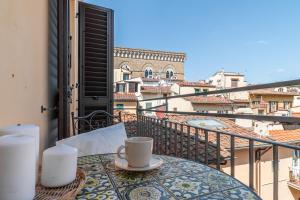 a cup of coffee sitting on a table on a balcony at The Tower Glimpse in Florence +24 photos