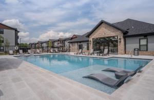 罗杰斯Luxuary Apt, Pool, Kingbeds, Near Amp的建筑物内设有带躺椅的游泳池