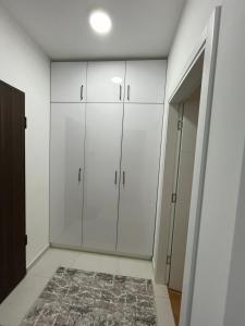 een kamer met witte kasten en een tapijt bij Zen Apartments in Rastoci