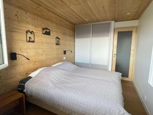 a bedroom with a bed in a wooden wall at Charmant 2 pièces 6 pers avec balcon sud, proche télé-siège et commerces à l'Alpe d'Huez - FR-1-405-3 in L'Alpe-d'Huez