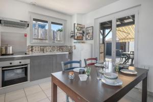 eine Küche mit Tisch und ein Esszimmer in der Unterkunft À 300m de la mer maison - jardin - Piscine pour 4 in Sainte-Marie