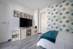 ein Schlafzimmer mit einem Bett und einem Flachbildfernseher in der Unterkunft À 300m de la mer maison - jardin - Piscine pour 4 in Sainte-Marie