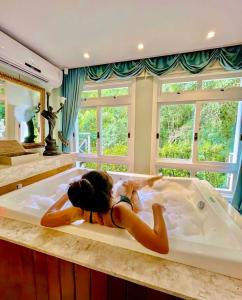 a woman laying in a bath tub in a room at Le Boutique Hotel Gramado - Exclusivo para Casais in Gramado