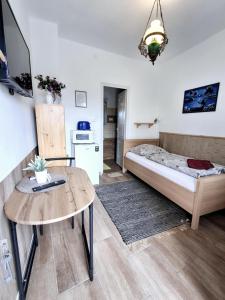 a room with a bed and a table and a tv at Szieszta Vendégház in Sárospatak