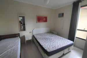 a bedroom with two beds and a mirror at Riviera Dreams: Piscina, Sauna e muito mais! in Bertioga +59 photos
