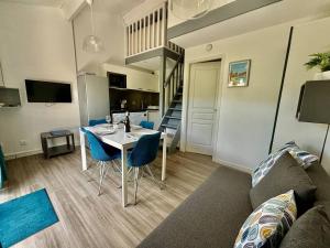 a living room with a table and blue chairs at Mazet Climatisé avec Parking et Piscine - FR-1-816-26 in Le Lavandou