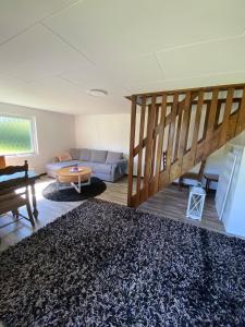 un soggiorno con un divano e una scala di Guest house in Röinge Hässleholm a Röinge