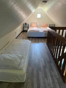 una camera mansardata con 2 letti e una scala di Guest house in Röinge Hässleholm a Röinge