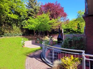 a garden with a fence and a walkway at Das Rosenhaus - luxoriöses Ferienhaus mit viel Platz für die ganze Familie von "Momentic" in Timmendorfer Strand