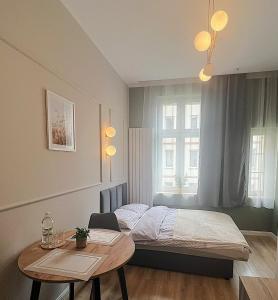 una piccola camera da letto con un letto e un tavolo di GREY Apartment 1 a Poznań