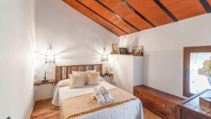 a bedroom with a bed with two towels on it at Cortijo Casablanca Villanueva de la Concepción by Ruralidays in Villanueva de la Concepción +28 photos