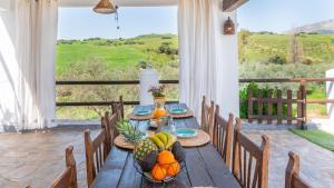 a wooden table with fruit on top of a porch at Cortijo Casablanca Villanueva de la Concepción by Ruralidays in Villanueva de la Concepción