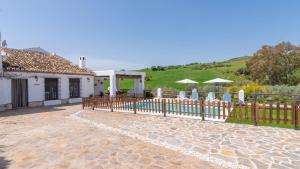a fence in front of a house with a pool at Cortijo Casablanca Villanueva de la Concepción by Ruralidays in Villanueva de la Concepción
