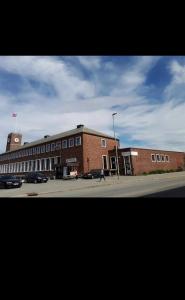 a large brick building with cars parked in a parking lot at Bodo Motel Norway in Bodø +11 photos