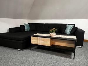 a black couch with a coffee table in a living room at Apartnám Lucy in Martin