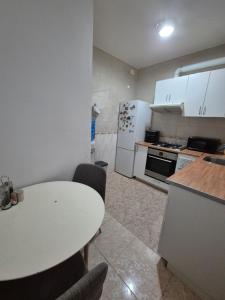 cocina con mesa blanca y nevera blanca en Mary home, en Barcelona