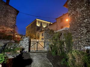 a building with a gate in front of it at night at En si bon chemin - Gîte chemin 65 in Le Monastier sur Gazeille