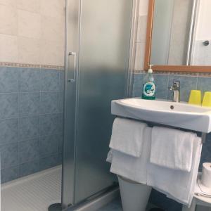 a bathroom with a sink and a shower with towels at Hotel Dania in Sorrento