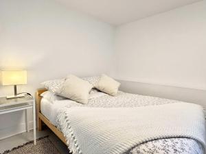 a bedroom with a bed with white sheets and a lamp at 4 Grandes Chambres Centre-Ville in Quebec City