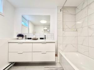 a white bathroom with a tub and a sink at 4 Grandes Chambres Centre-Ville in Quebec City +49 photos