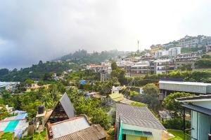 Blick auf eine Stadt mit Häusern auf einem Hügel in der Unterkunft FabHotel Rajathi Holiday Peak in Kodaikanal