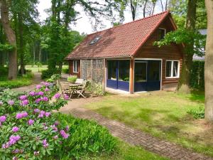 a small cottage with a picnic table and flowers at De Boase in Voorthuizen
