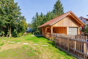 a wooden house with a fence next to a yard at Ferienhaus Lauwenhaus mit Sauna und eingezäunten Garten in Braunlage