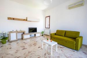 a living room with a green couch and a table at Casa Cloe Mondello in Palermo
