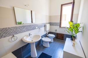 a bathroom with a sink and a toilet and a mirror at Casa Cloe Mondello in Palermo +17 photos